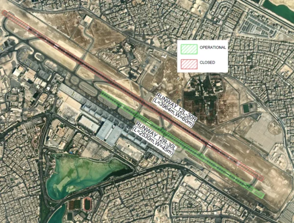 Satellite view of an airport showing two runways labeled 12L-30R and 12R-30L, with one marked operational and the other closed, surrounded by urban development and airport infrastructure.