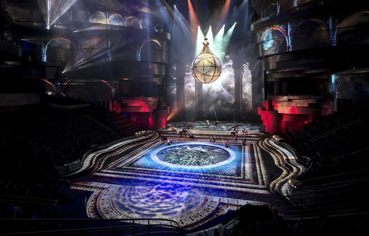 Interior of La Perle Aqua Theater in Dubai, showing a circular stage surrounded by a water performance arena.
