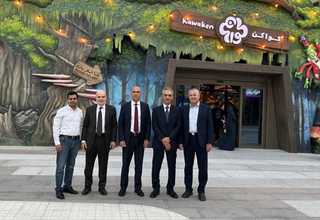 Six men in business attire posing in front of one of Seven Abha's entertainment venture