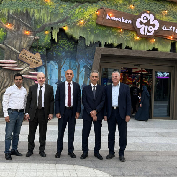 Six men in business attire posing in front of one of Seven Abha's entertainment venture